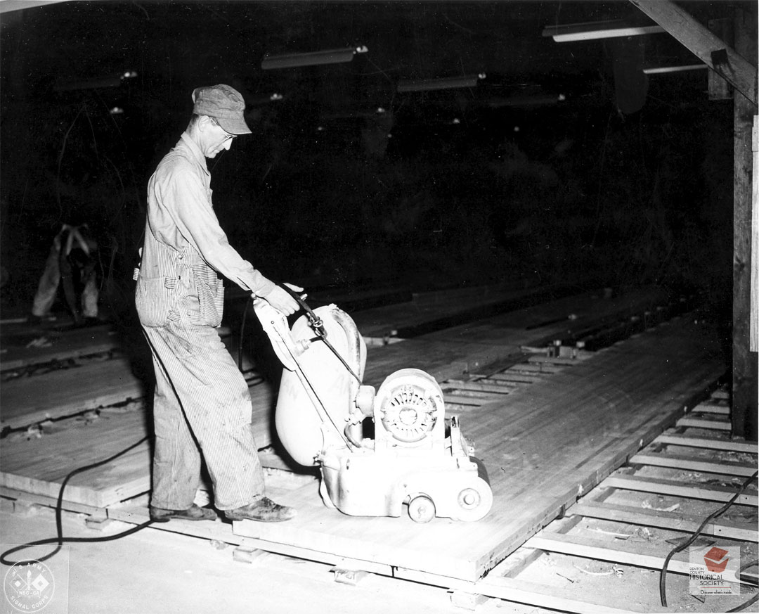 Man sanding the floor of ta bowling alley 